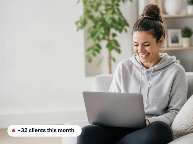 Fitness coach laughing at her laptop, with a +32 clients this month card